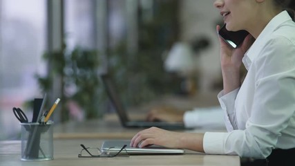 Happy young lady receiving phone call at office, talking with smile on face