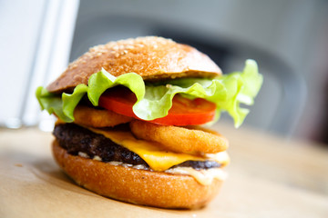 Hamburger with cheese, steak, onion rings and salad.