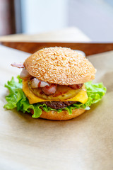 Hamburger with cheese, steak, onion rings, lettuce, pineapple an