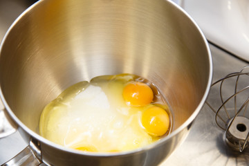 The eggs and sugar in the bowl of a blender before whipping.