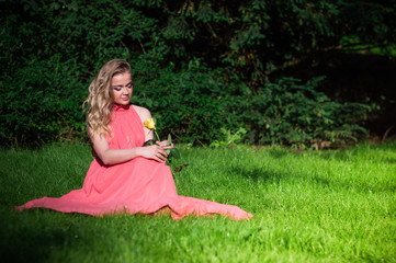 beautiful girl with a white rose in the Park on the grass