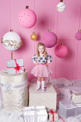 Pretty girl child 3 years old in a dress. Baby in Rose quartz room decorated holiday.