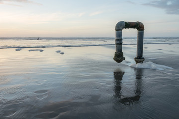Pipeline on ocean beach at sunset