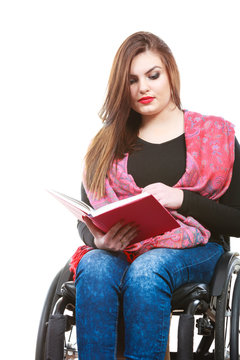 Young disabled woman in wheelchair with book.