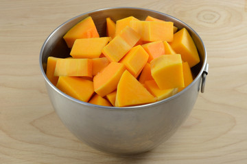 Raw uncooked butternut squash cubes in mixing bowl as cooking preparation