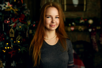 Happy red haired woman posing in christmas decoration