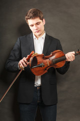 Fototapeta premium Man man dressed elegantly holding violin