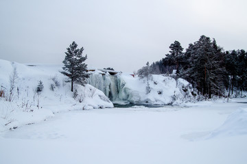 Winter waterfall near the frozen lake