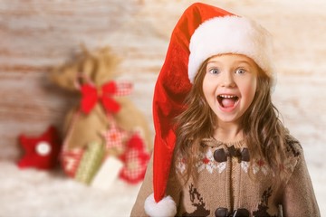 Happy child girl in a christmas hat.