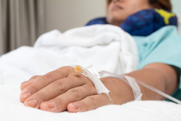 Focus on the hand of a patient near big window in hospital ward
