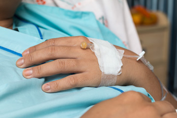 Focus on the hand of a patient in hospital ward