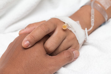 Friendly male hands holding female patient's hand for encouragem