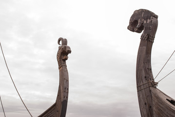 Viking warship at a shadow in the background of cloudy sky