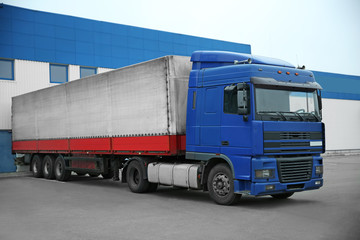 Truck on car parking near warehouse. Delivery and shipping concept.