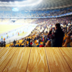 Obraz premium Wooden table against football stadium background