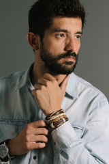 Advertising leather bracelets concept. Portrait of young man wearing leather bracelets and wrist watch