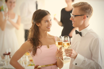 Young man and woman with glasses of champagne at party