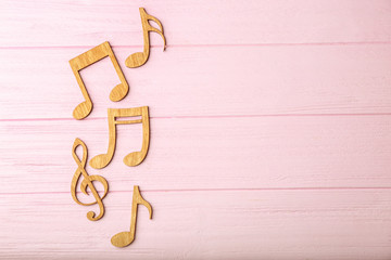 Musical notes on pink wooden background