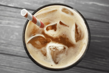 Glass of cold coffee on wooden background