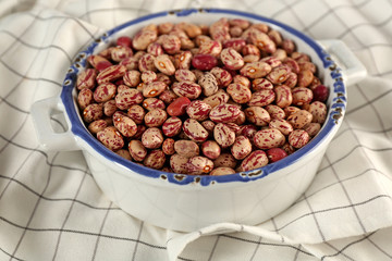 Bowl full of beans and napkin on a table