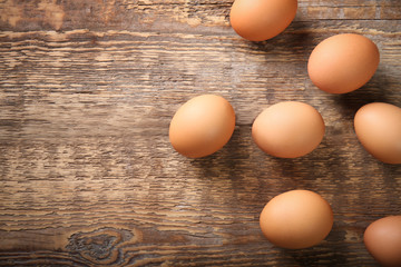 Raw eggs on wooden background