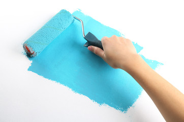 Female hand painting wall with roller