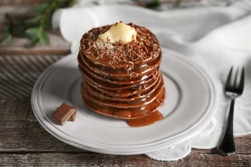 Tasty pancakes with chocolate sauce on plate