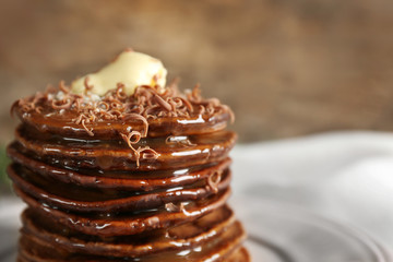 Tasty pancakes with chocolate sauce on blurred background