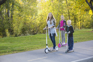 Family riding together outdoors on a paved bike pathway. Family is smiling and having fun together...