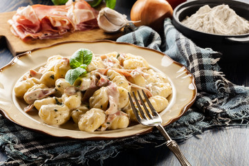 Potato gnocchi, Italian potato dumplings with cheese sauce, ham