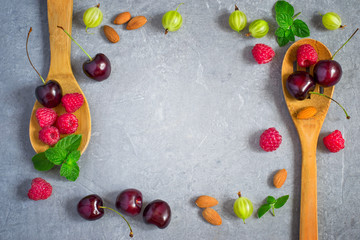 Juicy ripe berries frame laid out on a gray background. Top view