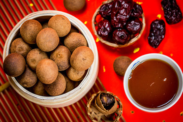 Chinese longan date soup in red background.