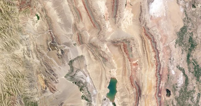 High-altitude overflight aerial of thrust belt rock layers, Xinjiang province, China. Clip loops and is reversible. Elements of this image furnished by USGS/NASA Landsat