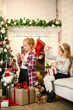 Little girls decorating Christmas tree and preparing gifts