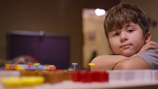 A little boy smiling, and using cookie cutters