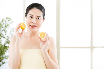 Obraz na płótnie Canvas Beautiful asian woman holding slices of lemon. healthy beauty