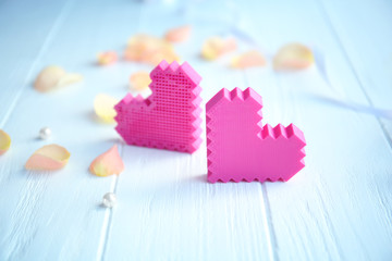 Pink hearts with flower petals on table