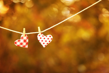 Hearts hanging on clothes pins on green background
