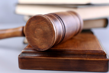 Judge's gavel with sound block and books on background