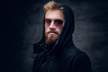 Fototapeta premium A bearded male in sunglasses and in a hood.