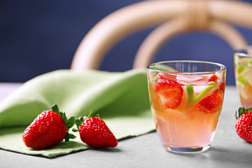Glass with strawberry cocktail on table