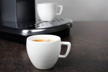 Cup of aromatic espresso on grey table