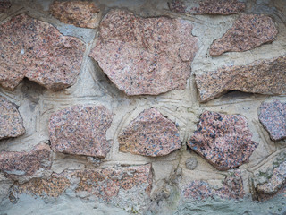Background of natural stone wall texture close up. Pink stone pattern. An abstract mosaic.