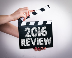 2016 Review concept. Female hands holding movie clapper. 
