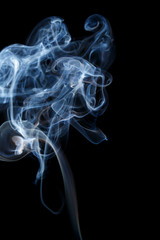Abstract art. Color white blue smoke from the aromatic sticks on a black background. Background for Halloween. Texture fog. Design element. The concept of aromatherapy.