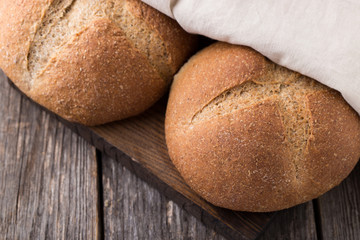 Wholemeal wheat bread on wooden background. Close up
