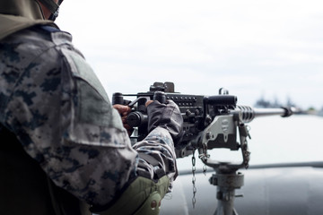 Selected focus Navy soldier hand on machine gun on