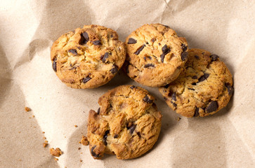Chocolate cookies in brown paper, Chocolate chip cookies on wood