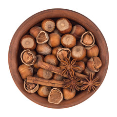 Fototapeta na wymiar Hazelnuts in a brown plate. Isolated on white background.