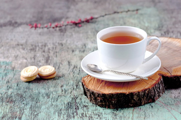 A cup of hot herbal tea and cookies on the old wooden background. Cup of tea herbal tea hot drink Baking Cookies Vintage texture background